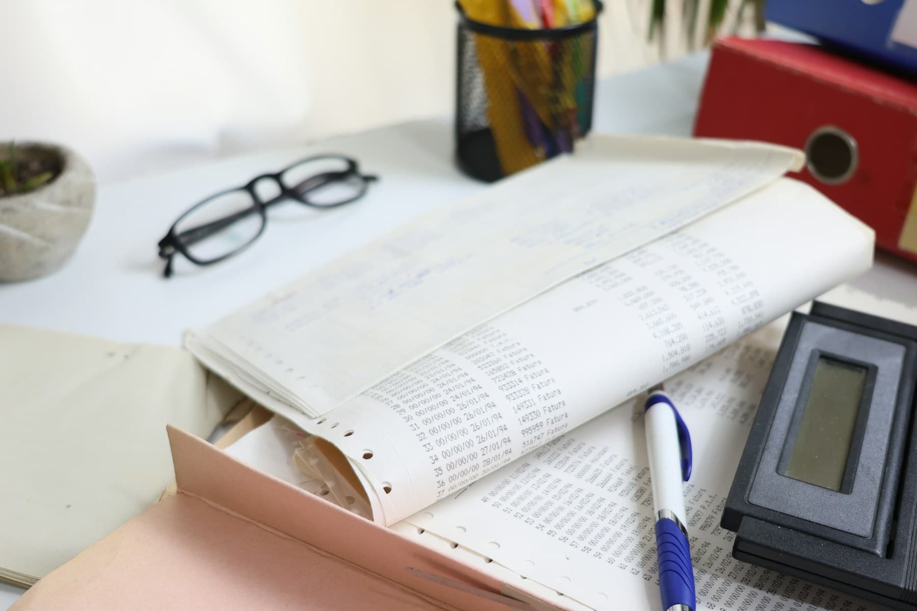 Paperwork, calculator, and office supplies on a desk