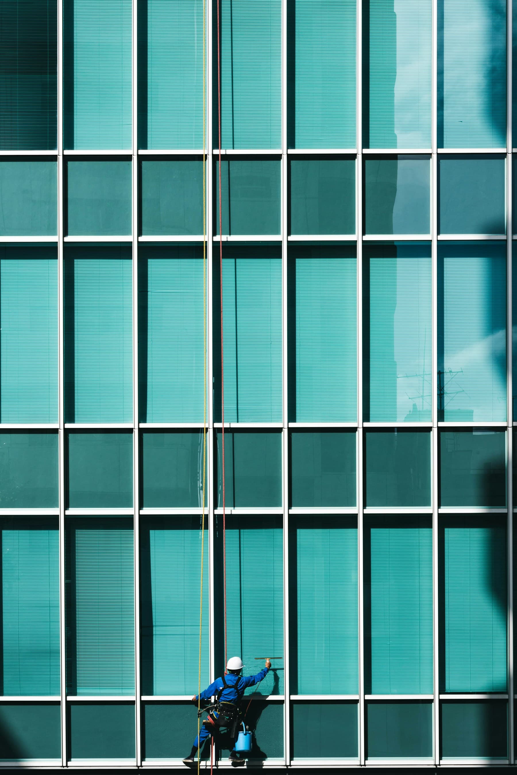 Worker cleaning large exterior windows on a commercial building