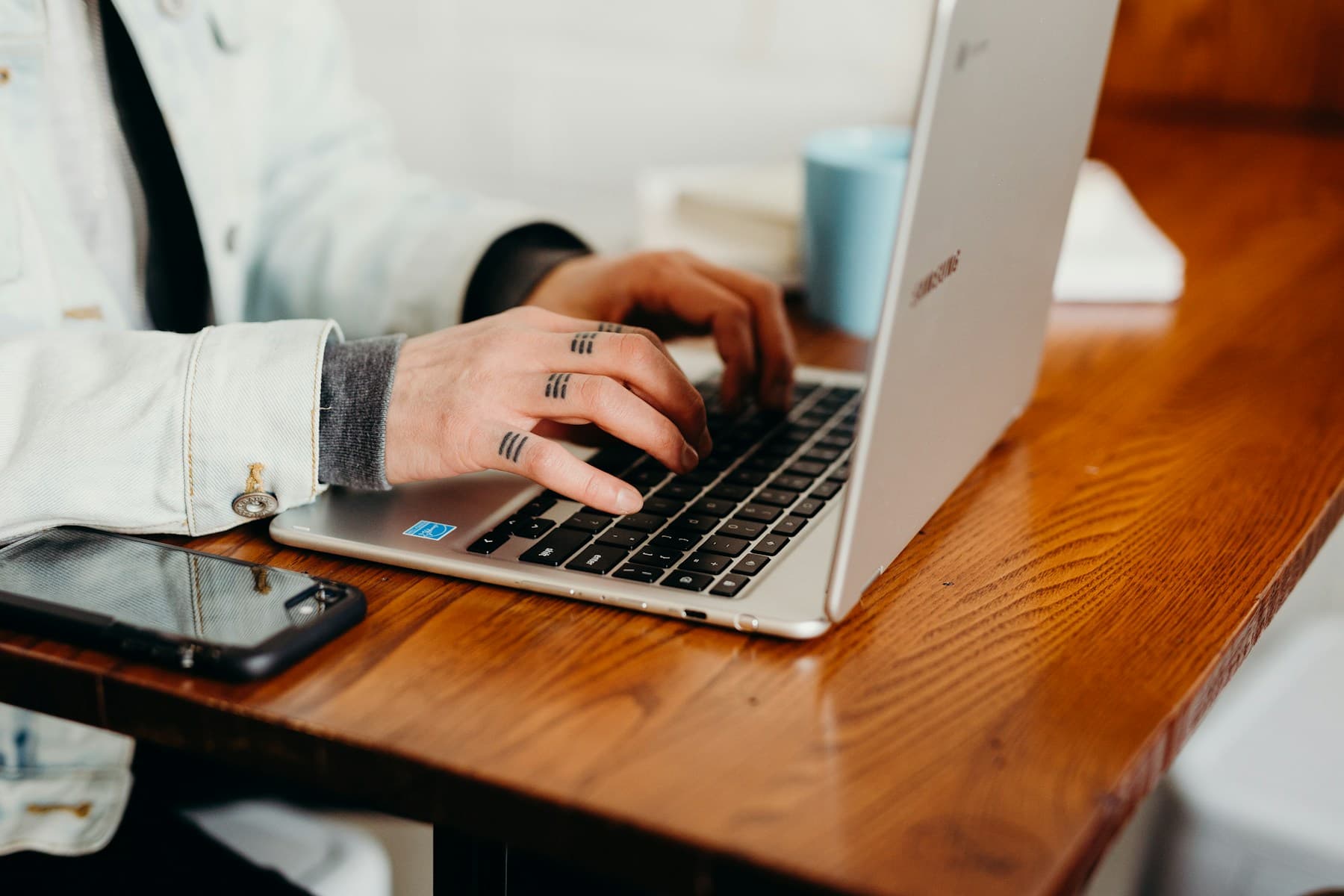 Person working on a laptop and tablet at a table