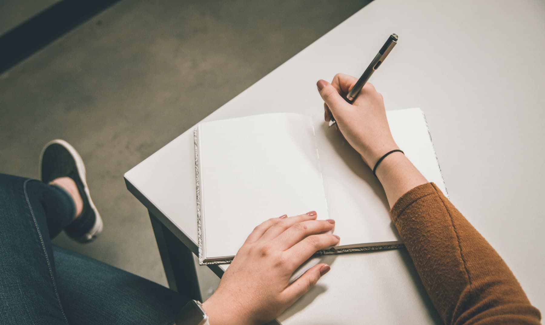 Person writing notes in a business meeting