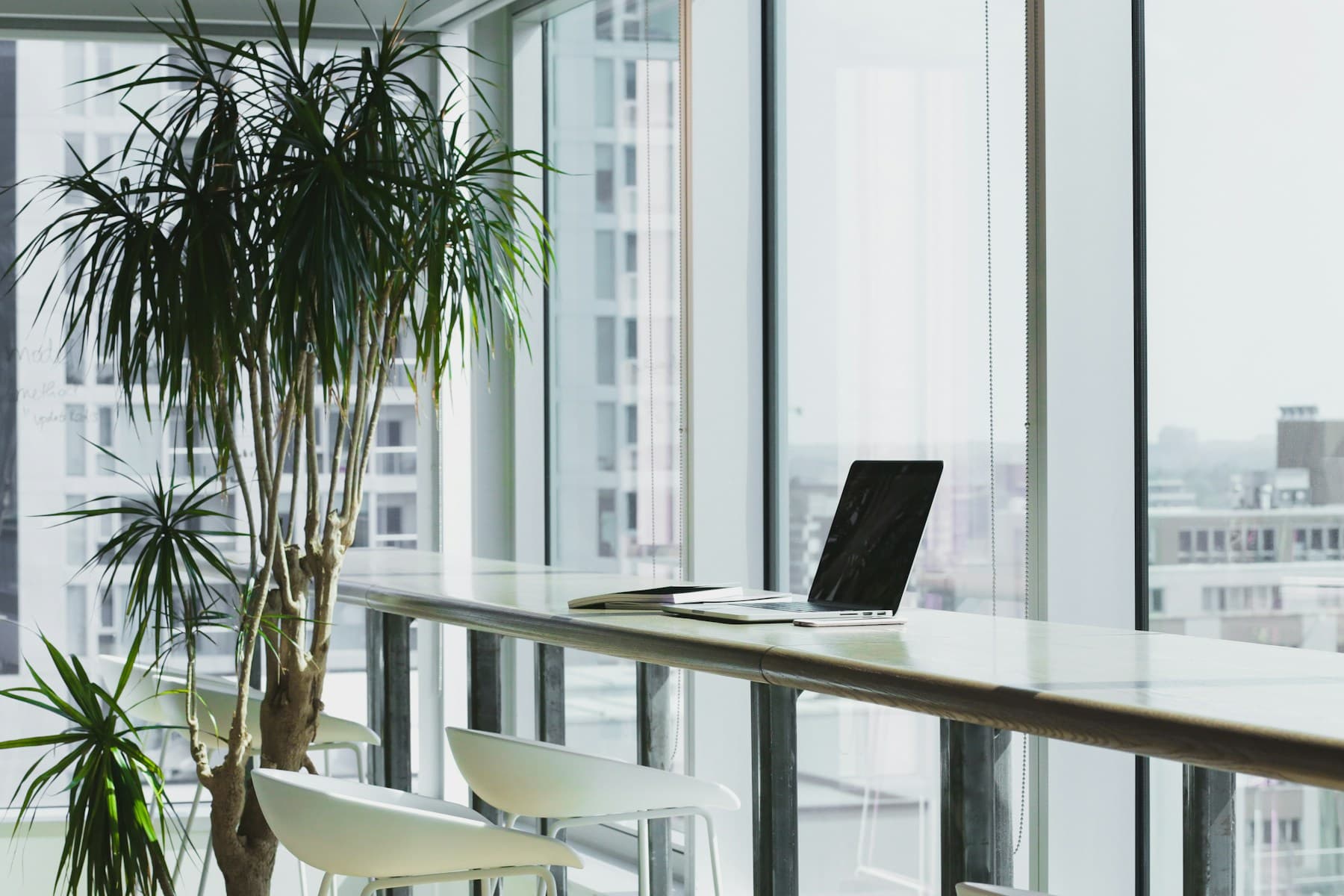 Laptop on a wooden desk in a shared workspace