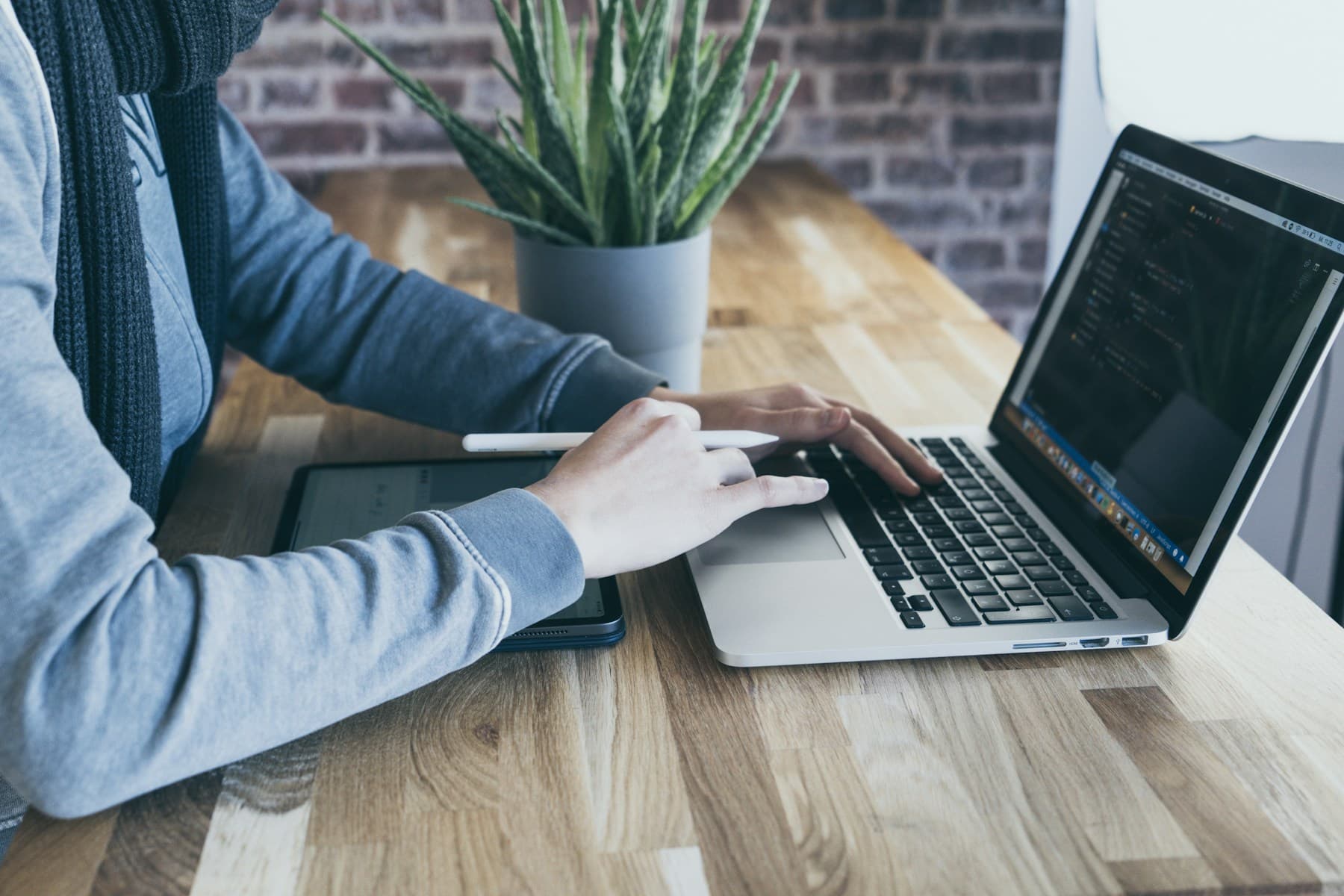 A small-business workspace with a laptop and tablet for reviewing software options